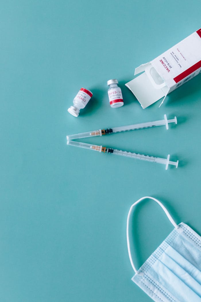 Syringes, vaccine vials, and face mask ready for COVID-19 vaccination.